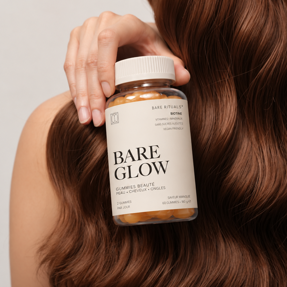 Femme aux cheveux longs et brillants tenant le pot de gummies beauté Bare Glow de Bare Rituals.